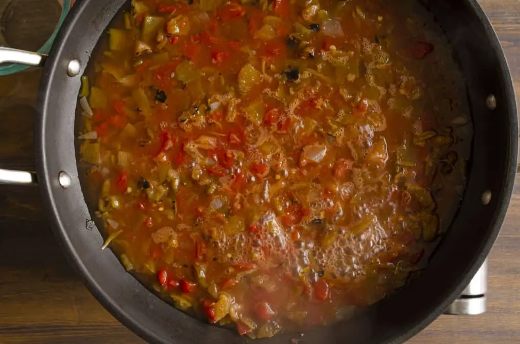 Looking down into a large non-stick skillet simmering salsa.