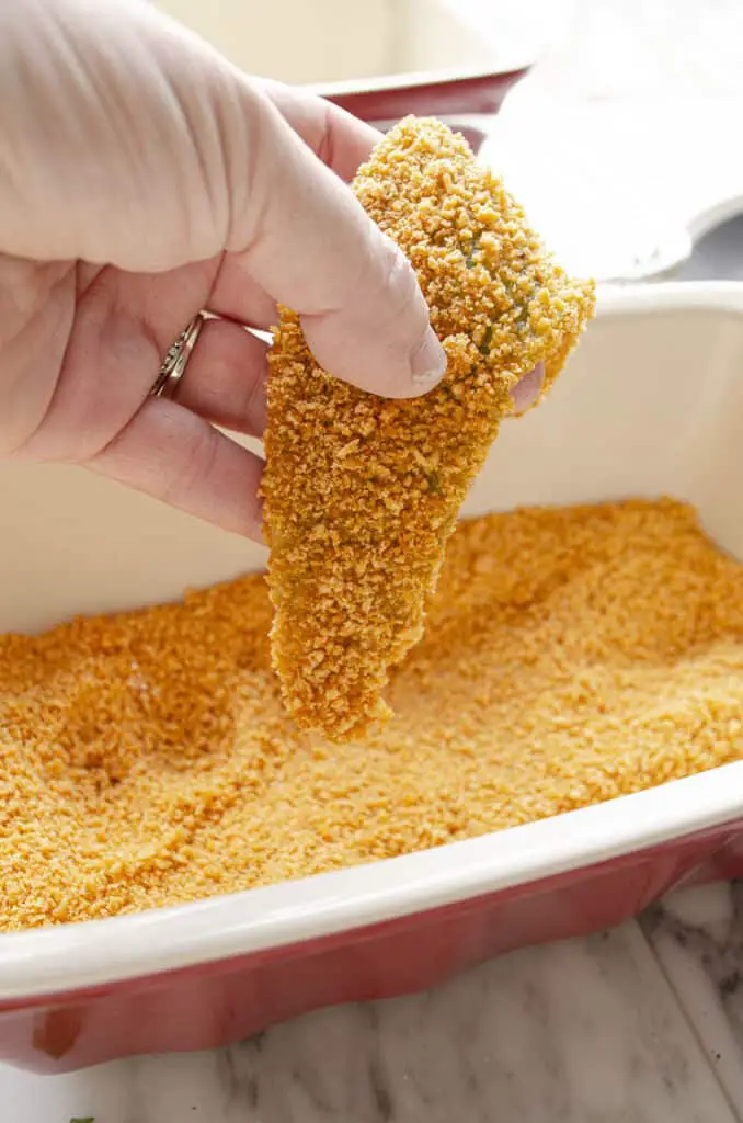 A closeup of a chile strip coating in crunchy breading crumbs.