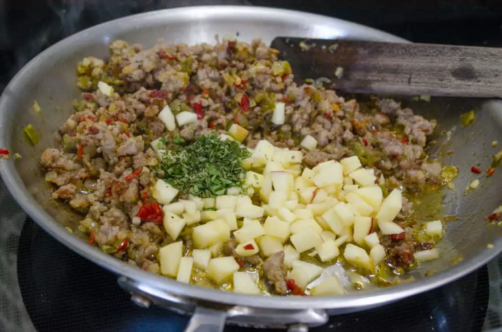 Diced apple and herbs are added to a sausage, onion, green chile mixture for Green chile and Sausage stuffed Acorn squash.