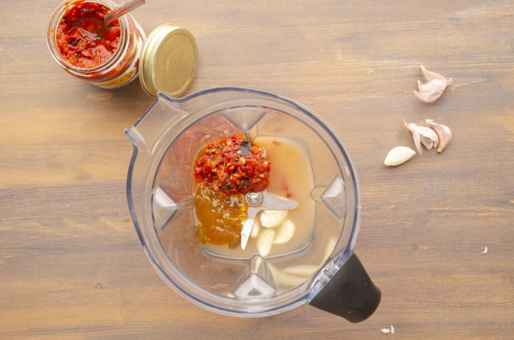 Looking down into a blender showing the ingredients for Sweet and Spicy Hatch Chile Marinade and Glaze.