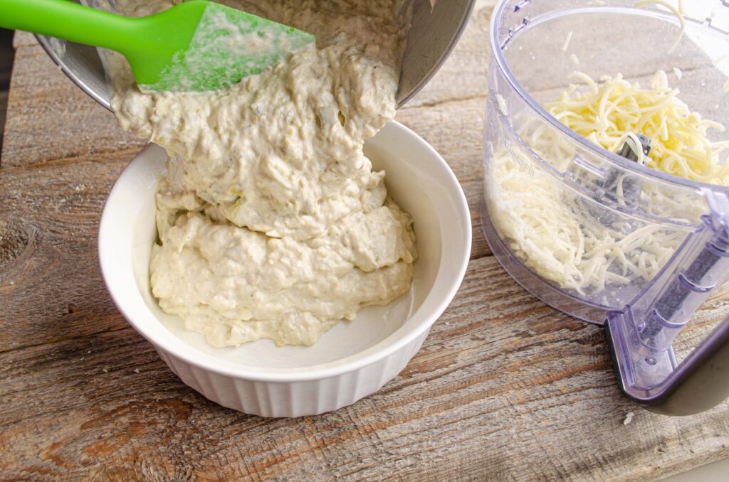 Skinny Hatch Green Chile Chicken Dip being poured into a baking dish. 