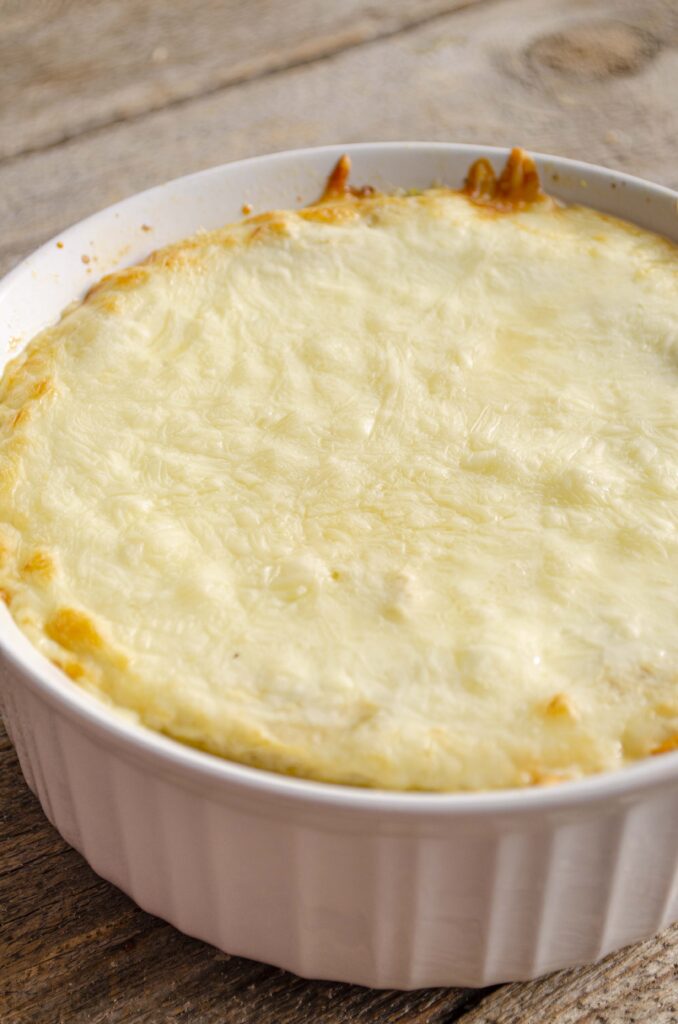 A closeup of a baking dish bubbling with hot Skinny Hatch Green Chile fresh from the oven.