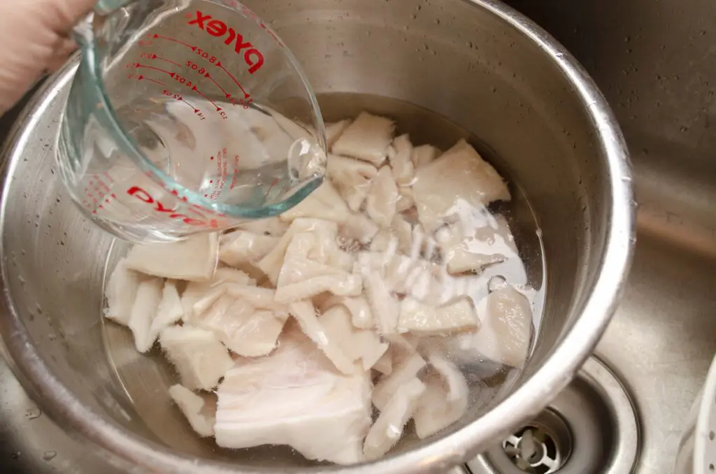 Vinegar is poured into a large bowl with  water and chopped tripe.