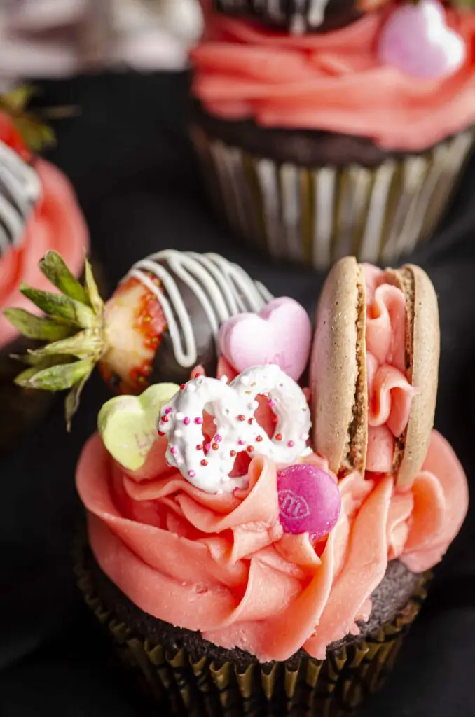 A very close-up picture highlighting the treats atop of a Dark Chocolate Loaded Valentine's Day Cupcake.