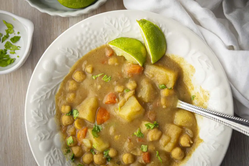 Looking down on a white bowl filled with Coconut Curry Stew featuring canned chickpeas.