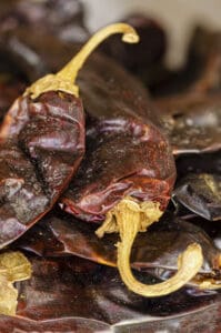  A pile of dried red chiles with their yellow stems still attached.