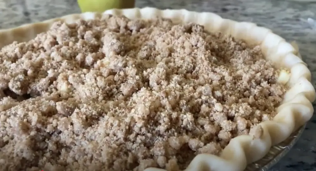 A Browned Butter Cream Apple Pie is covered with a crumble topping.