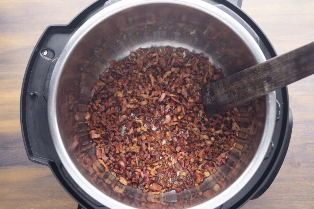 Looking down into an Instant Pot that is cooking chopped bacon.